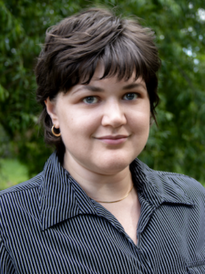 Photo of Anastasia Wheeler in front of leafy. trees